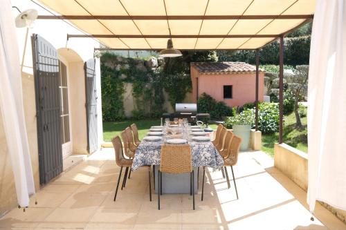 a table and chairs on a patio with a table and a laptop at Air-conditioned villa with heated pool, Luberon, in Puget - 10 people in Puget
