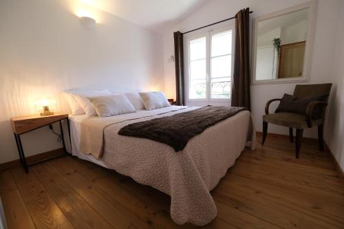a bedroom with a bed and a chair and a window at Air-conditioned villa with heated pool, Luberon, in Puget - 10 people in Puget