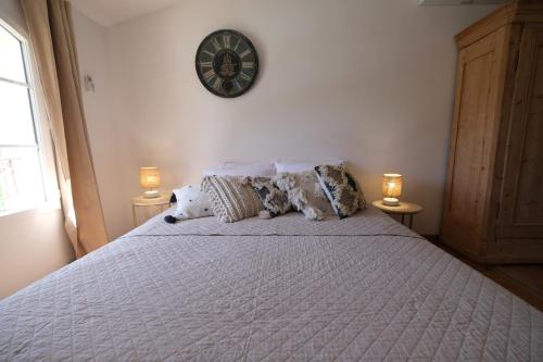 a bedroom with a bed with a clock on the wall at Air-conditioned villa with heated pool, Luberon, in Puget - 10 people in Puget