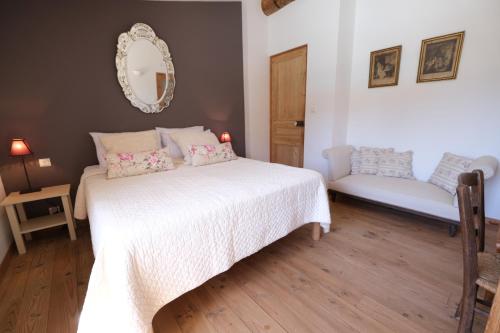 a bedroom with a white bed and a couch at Air-conditioned villa with heated pool, Luberon, in Puget - 10 people in Puget