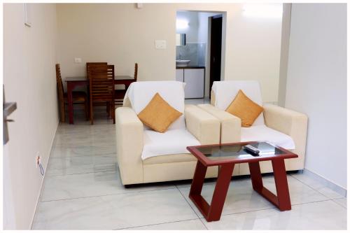 a living room with two chairs and a coffee table at Vajra Periyar Heritage in Alwaye