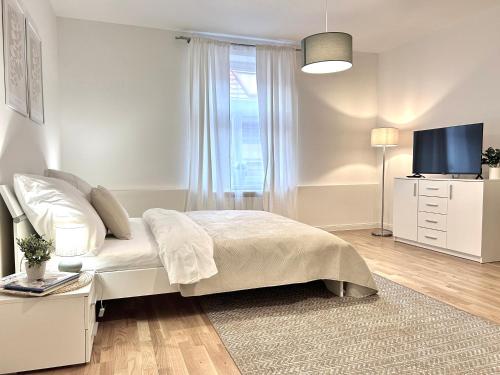 une chambre blanche avec un lit et une télévision dans l'établissement Treetess City Centre Prague Apartments, à Prague