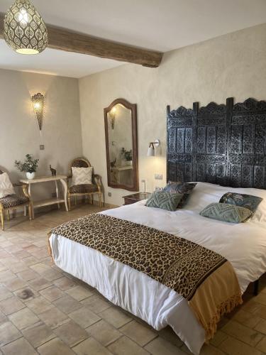 une chambre avec un grand lit avec une grande tête de lit dans l'établissement Provencal farm with heated pool in Lamanon near Aix en Provence - 12 people, à Lamanon