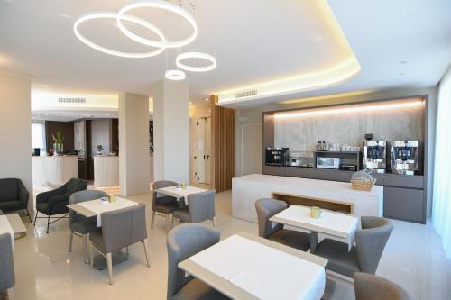a restaurant with tables and chairs and a kitchen at Albergo Grappolo D'oro in Montebelluna