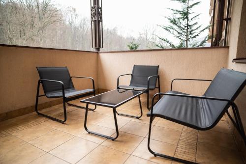 three chairs and a table in front of a window at Solva Resort Medical & SPA in Polyana