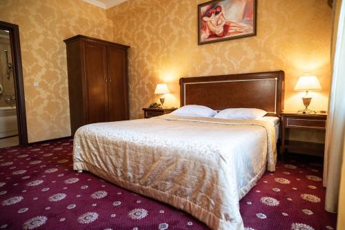 a hotel room with a bed and two nightstands and two lamps at Solva Resort Medical & SPA in Polyana