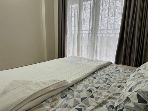 a bed in a bedroom with a window at Memmsta Blooming Bird Guruvayur in Guruvāyūr