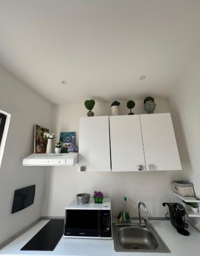 a kitchen with white cabinets and a sink at Casa vacanze Manzoni 287 PT in Perugia