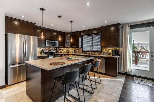 a kitchen with a large island with bar stools at Chalet au Boisé in Saint Come