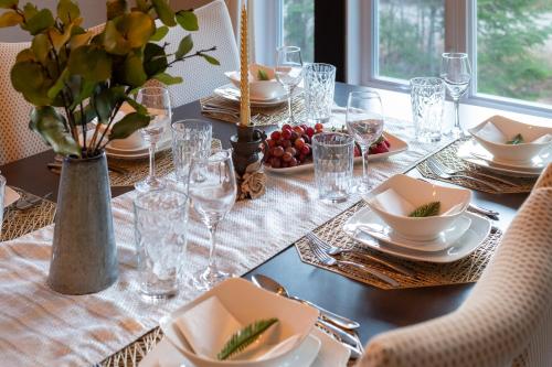 a dining table with plates and glasses on it at Chalet au Boisé in Saint Come