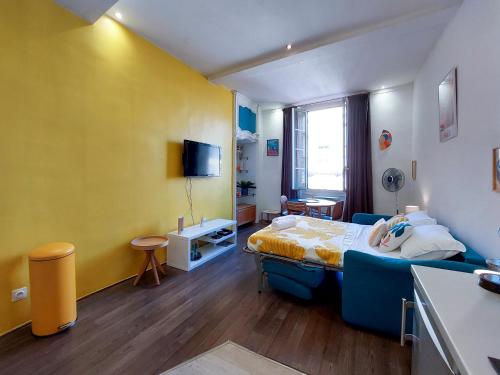 - une chambre avec un lit bleu et un mur jaune dans l'établissement Rossetti 4 Pers Vecchia Nizza WiFi, à Nice