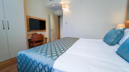 a bedroom with a large white bed with blue pillows at Grand Sirkeci Hotel in Istanbul