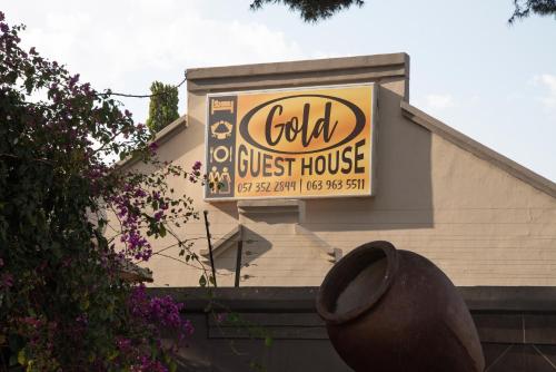 a sign for a guest house on the side of a building at Gold Guest & Conference in Welkom