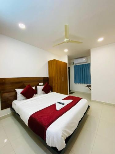 a bedroom with a large bed with red pillows at HK Guest Rooms in Guntūr