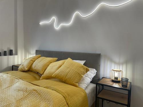 uma cama com um edredão amarelo e almofadas em Silesia Blue2 Apartment - Katowice em Katowice