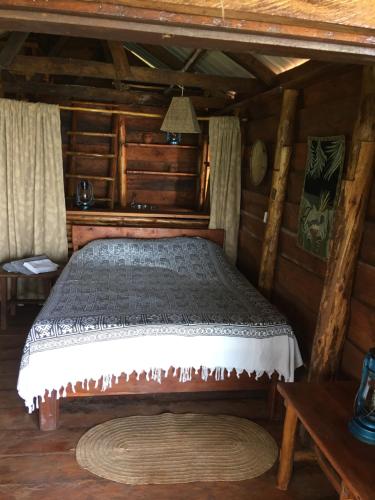 a bedroom with a bed in a log cabin at Villa Kinyonga, Camp Mawingu in Muheza