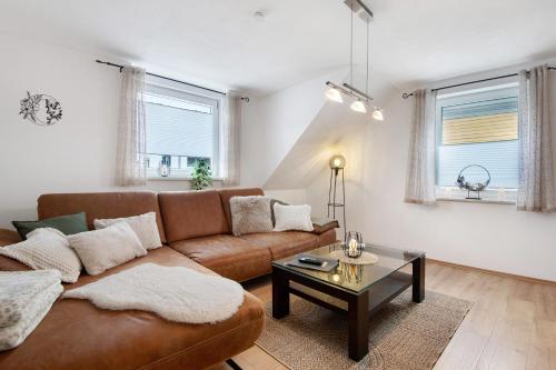 a living room with a brown couch and a table at Ferienwohnung aufm Weinberg 0G in Schwandorf in Bayern