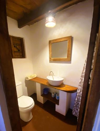 a bathroom with a white toilet and a sink at Villa Kinyonga, Camp Mawingu in Muheza
