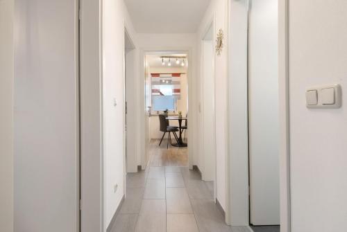 a hallway with white walls and a table in a room at Ferienwohnung aufm Weinberg 0G in Schwandorf in Bayern