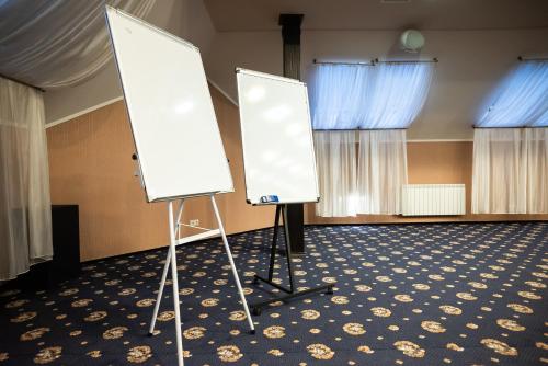 two whiteboards on display in a room with blue curtains at Solva Resort Medical & SPA in Polyana
