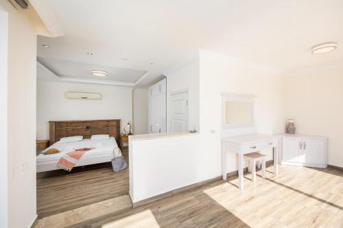 a white bedroom with a bed and a desk at Residence Villa 1 in Oludeniz