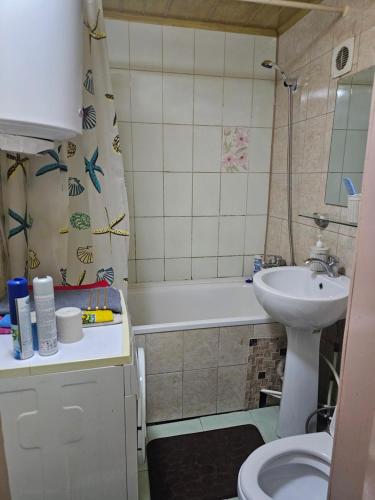 a bathroom with a sink and a tub and a toilet at Уют2 in Pavlodar