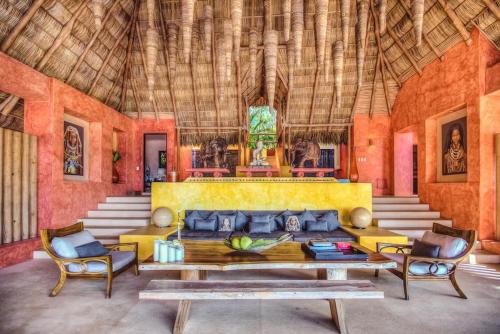 a living room with a yellow couch and two chairs at Casa Mis Amores in Sayulita