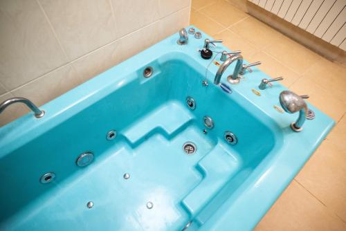 a blue tub with a faucet in a bathroom at Solva Resort Medical & SPA in Polyana