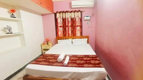 a bedroom with a large bed in a pink wall at Thiru Arunesha Family Home Stay Tiruvannamalai in Tiruvannāmalai