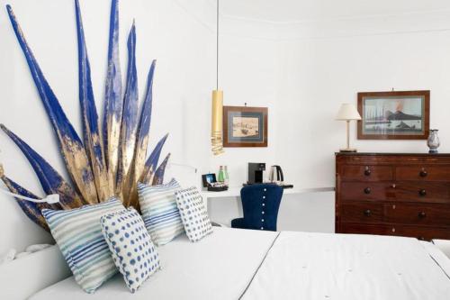 a bedroom with a bed with pillows and a dresser at Hotel Le Agavi in Positano