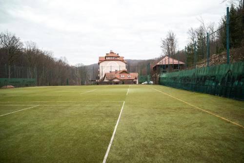 a tennis court with a building in the background at Solva Resort Medical & SPA in Polyana