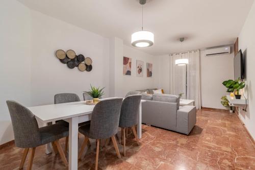 a living room with a table and chairs and a couch at A estrenar pleno centro, parking in Huelva