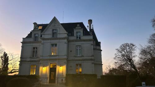 a large white house with its lights on at Domaine de la Tortinière in Montbazon