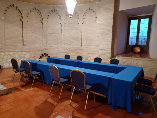a long blue table and chairs in a room at Hotel Maria Cristina in Toledo