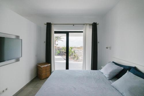 Un dormitorio con una cama y una ventana grande. en Casa Agua Nueva 53, en La Frontera