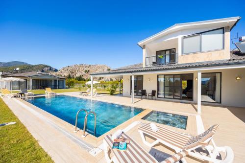 a home with a swimming pool and a house at Villa Tolga in Dalyan