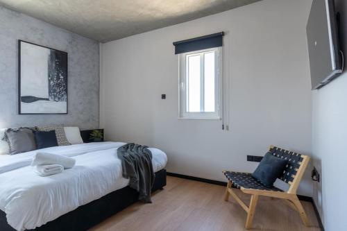 a bedroom with a bed and a chair and a window at The Penthouse - 3BR Seaview with Private Pool in Larnaca in Larnaca