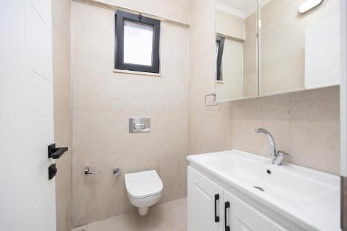 a bathroom with a toilet and a sink and a window at Villa Funda in Dalyan