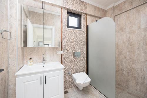 a bathroom with a toilet and a sink and a mirror at Villa Tolga in Dalyan