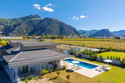 an aerial view of a house with a swimming pool and mountains at Villa Tolga in Dalyan