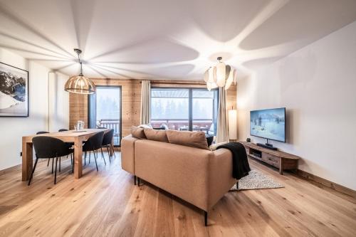 un salon avec un canapé et une table dans l'établissement Apartment Gentiana, Les Gets - by EMERALD STAY, aux Gets