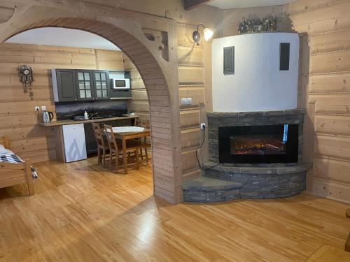 a living room with a stone fireplace in a house at U Wajdy in Male Ciche