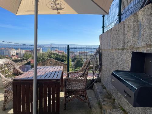 einen Tisch und Stühle mit Sonnenschirm auf dem Balkon in der Unterkunft Mobilhome en Ribeira con vistas in Ribeira