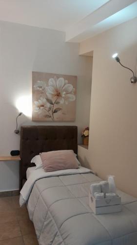 a bedroom with a bed with a flower painting on the wall at Rainbow Sweet Rooms in Valmontone