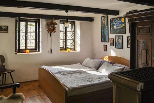 a bedroom with a bed in a room with windows at útulná chalupa v blízkosti Znojma, velmi klidné prostředí in Němčičky