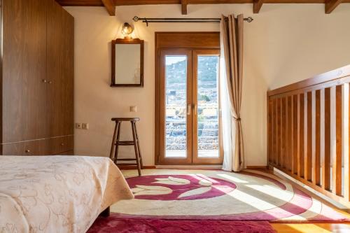 a bedroom with a bed and a large window at Mareu Stonehouse in Panóramo