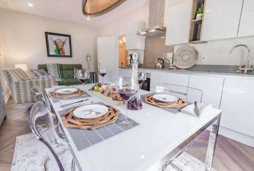 a kitchen with a table with plates and wine glasses at The Corner Loft in Ballycastle