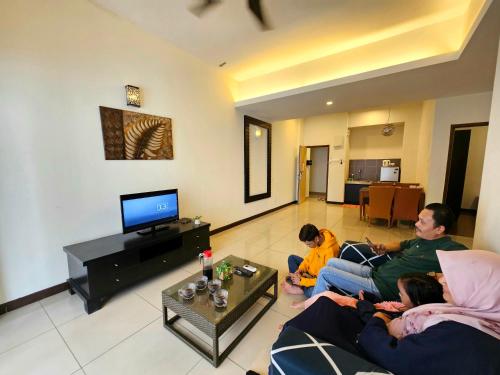 a group of people sitting in a living room at Melaka Town Area Top 1 Family Lovers Water Themepark Suites By GGM in Melaka