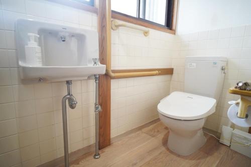 a bathroom with a toilet and a sink at 一棟貸切AKARIYA Home in Karatsu