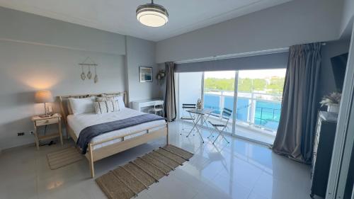 a bedroom with a bed and a balcony at Elegante Blue Marine Apartamento Juan Dolio in Juan Dolio